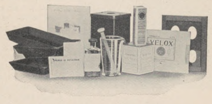 Contents of the A B C Developing Outfit including trays, lamp, graduate and packets.